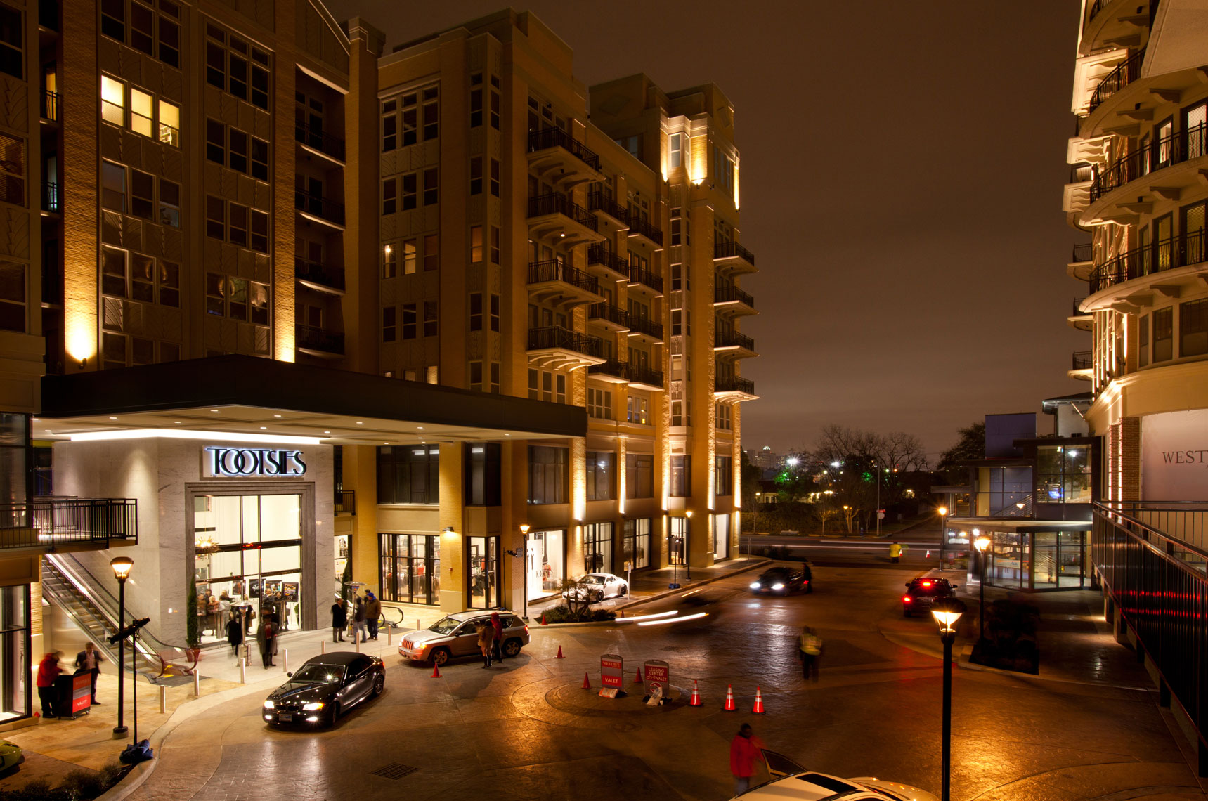 an architectural photo of a retail shopping center at night in Houston Texas